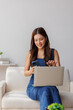 © David - Young woman multitasking with laptop and smartphone at home