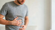 © Xenia - Man holding his stomach in pain. Adult male rubbing belly experiencing indigestion or nausea. Healthcare and medical concept. Copy space for text