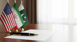 © Kristelinmind - Flags of USA, Iran and Pakistan on a table with a fountain pen and document. International relations, diplomatic peace negotiations and conflict resolution agreement. Global politics.