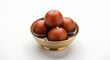© Zobia - Perspective studio shot of four juicy Gulab Jamun dessert balls garnished with melon seeds, served in a traditional antique brass bowl filled with sweet aromatic syrup, representing luxury South Asian
