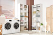 © Pixel-Shot - Interior of laundry room with washing machines, shelf units and stacked linen