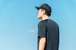 © buritora - A man in sportswear standing under a blue sky (training, exercise habit, morning routine)