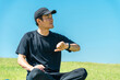 © buritora - A middle-aged man in sportswear uses a smartwatch and smart band to do yoga, stretching, and healthcare.