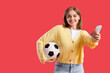 © Pixel-Shot - Happy young woman with soccer ball and money on red background. Sports bet concept