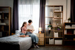 © Montri - Mother and daughter reading a book together on bed in cozy bedroom, warm family bonding, parenting, education, love, trust, bedtime story, peaceful home lifestyle indoor scene