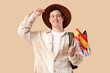 © Pixel-Shot - Young happy man with different flags and backpack on beige background