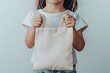 © sahda - Child Holding a Blank Tote Bag.