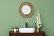 © Pixel-Shot - Modern sink with bath supplies on countertop and stylish mirror near green wall in bathroom