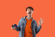 © Pixel-Shot - Surprised young man with credit cards on orange background