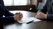 © warnadi - Solemn moment as hands rest on a legal document with wedding rings, symbolizing the difficult finalization of a divorce settlement or a significant marital separation agreement