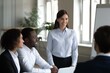 © Juan - Businesswoman leading meeting with coworkers showing leadership communication and professional workplace collaboration environment
