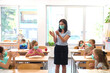 © .shock - Teacher and elementary students wearing masks in classroom clapping and celebrating safe return to school