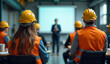 © Rhony - Construction workers are having a meeting in an industrial building with a woman explaining in front of a screen.