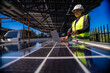 © ultramansk - Engineer in safety vest and helmet pointing towards a solar powered carport, illustrating eco-friendly innovation in parking infrastructure. Solar panels provide shade and sustainable energy.