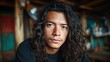 © svastix - A close-up of a pensive young man with long curly hair, conveying depth of thought and emotion, inviting viewers to connect with his reflective expression and gaze.
