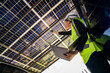 © ultramansk - Engineer in safety vest and helmet pointing towards a solar powered carport, illustrating eco-friendly innovation in parking infrastructure. Solar panels provide shade and sustainable energy.