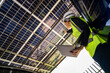 © ultramansk - Engineer in safety vest and helmet pointing towards a solar powered carport, illustrating eco-friendly innovation in parking infrastructure. Solar panels provide shade and sustainable energy.