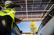 © ultramansk - Engineer in safety vest and helmet pointing towards a solar powered carport, illustrating eco-friendly innovation in parking infrastructure. Solar panels provide shade and sustainable energy.