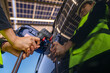 © ultramansk - Engineer in safety vest and helmet pointing towards a solar powered carport, illustrating eco-friendly innovation in parking infrastructure. Solar panels provide shade and sustainable energy.