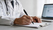 © 白 李 - Doctor writing on clipboard with laptop