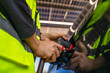 © ultramansk - Engineer in safety vest and helmet pointing towards a solar powered carport, illustrating eco-friendly innovation in parking infrastructure. Solar panels provide shade and sustainable energy.