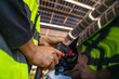 © ultramansk - Engineer in safety vest and helmet pointing towards a solar powered carport, illustrating eco-friendly innovation in parking infrastructure. Solar panels provide shade and sustainable energy.