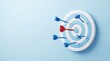 © DreamStock - A single red dart hitting the bullseye of a light blue target with several blue darts scattered around on a solid light blue background