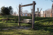 © KOSHKAROV SERGEI - Wooden bench swing standing idle in a grassy outdoor park area
