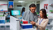 © DC Studio - Woman specialist looking at smartphone to give pills to client, searching for medical treatment on shelves. Showing drugs and pharmaceutical products, pharmacy healthcare medicaments.