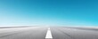 © Photo18@desing - Low angle, minimalist view of an empty asphalt road with leading white lines receding into the horizon under a vast gradient blue sky, symbolizing future journeys and infinite