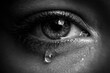 © TheWaterMeloonProjec - Detailed black and white close up of a human eye expressing sorrow with a teary pupil