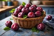 © NeuralNiche - A basket filled with ripe burgundy plums on a blue painted wooden kitchen table