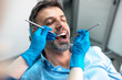 © Graphicroyalty - Close up of man during dental procedure with doctor hands in gloves. Stomatology examination using tools and mirror in clinic. Professional teeth care, oral hygiene and healthcare intervention.
