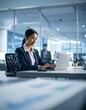 © hoy - Professional woman working on a laptop in an office
