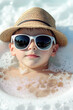 © Ева Поликарпова - A young boy wearing sunglasses and a straw hat, perfect for summer or outdoor activities. vertical frame