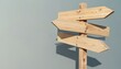 © miss irine - Wooden signpost with multiple arrow signs points in various directions. Choose your path with these directional wood planks against a soft grey wall backdrop.
