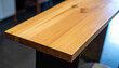 © Adobe worker  - Close-up of a smooth light wood countertop edge with dark base table desk