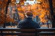 © Martinesku - An elderly man sits alone on a park bench surrounded by warm autumn colors in a quiet reflective moment. Retirement, loneliness, and social support create a thoughtful aging and pension concept.