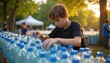 © Viktor - Young boy sorts plastic bottles at outdoor community event. Teenager helps with recycling effort in park during sunny day. Volunteer collects trash for eco friendly initiative.
