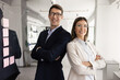 © fizkes - Young 30s Spaniard businesspeople, motivated employees professionals looking at camera, standing confidently side by side in modern workspace, engaged in productive teamwork. Partnership, leadership