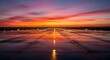 © Syafiq - Vibrant sunset over a wet airport runway with runway lights reflecting.