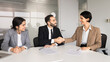 © fizkes - Smiling multiethnic businesspeople sitting at conference table with signed contracts, handshaking, finalize legal commercial deal, starting business partnership. Successful agreement, collaboration