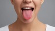 © 69 - Close-up of Woman Sticking Out Her Tongue Against Neutral Background, Expressing Playfulness and Fun in Portrait Photography