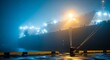 © thenort - Large cargo vessel docked in a port at night, shrouded in thick fog, illuminated by lights