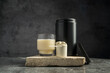 © Inga - Protein shake in drinking glass and scoop with whey protein powder on dark background, copy space