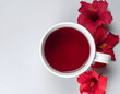 © Diga - Vibrant red hibiscus tea infusion in a white cup with tropical flowers and star anise, elegant wellness and herbal concept, top view,  digital art, AI generated, copy space