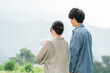 © buritora - A young couple holding their baby in a rural landscape.