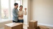 © spyrakot - Young adult couple standing near sunlit window with moving boxes