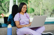 © Tirso Lecointere - Latin hispanic healthcare worker wearing scrubs and stethoscope, studying and working on laptop while sitting outdoors