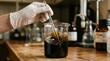 © Creativeraf - Scientist stirring a dark viscous liquid in a glass beaker in a laboratory